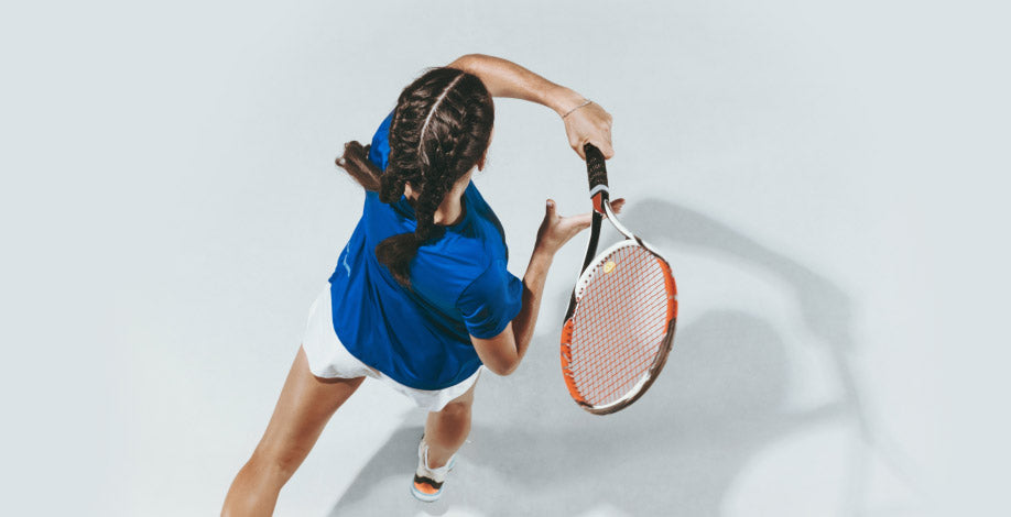 Girl with braids playing tennis on white background